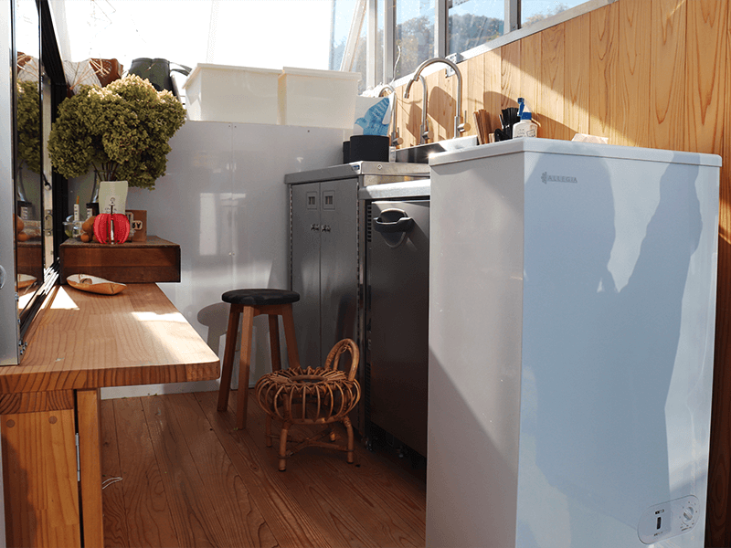 トラックの中には、シンクとコンパクトな冷蔵庫のキッチンを完備。床もフローリングを貼って家のような雰囲気に